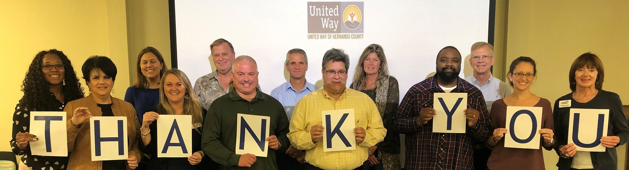 Board of Directors holding up THANK YOU sign