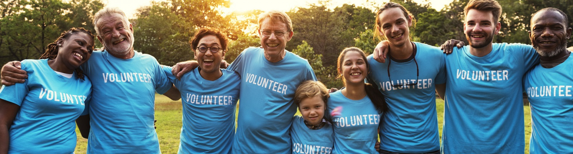 Group individuals of all ages wearing VOLUNTEER t-shirts